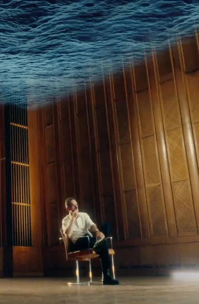 A man sitting alone on a chair in a huge wooden conference hall