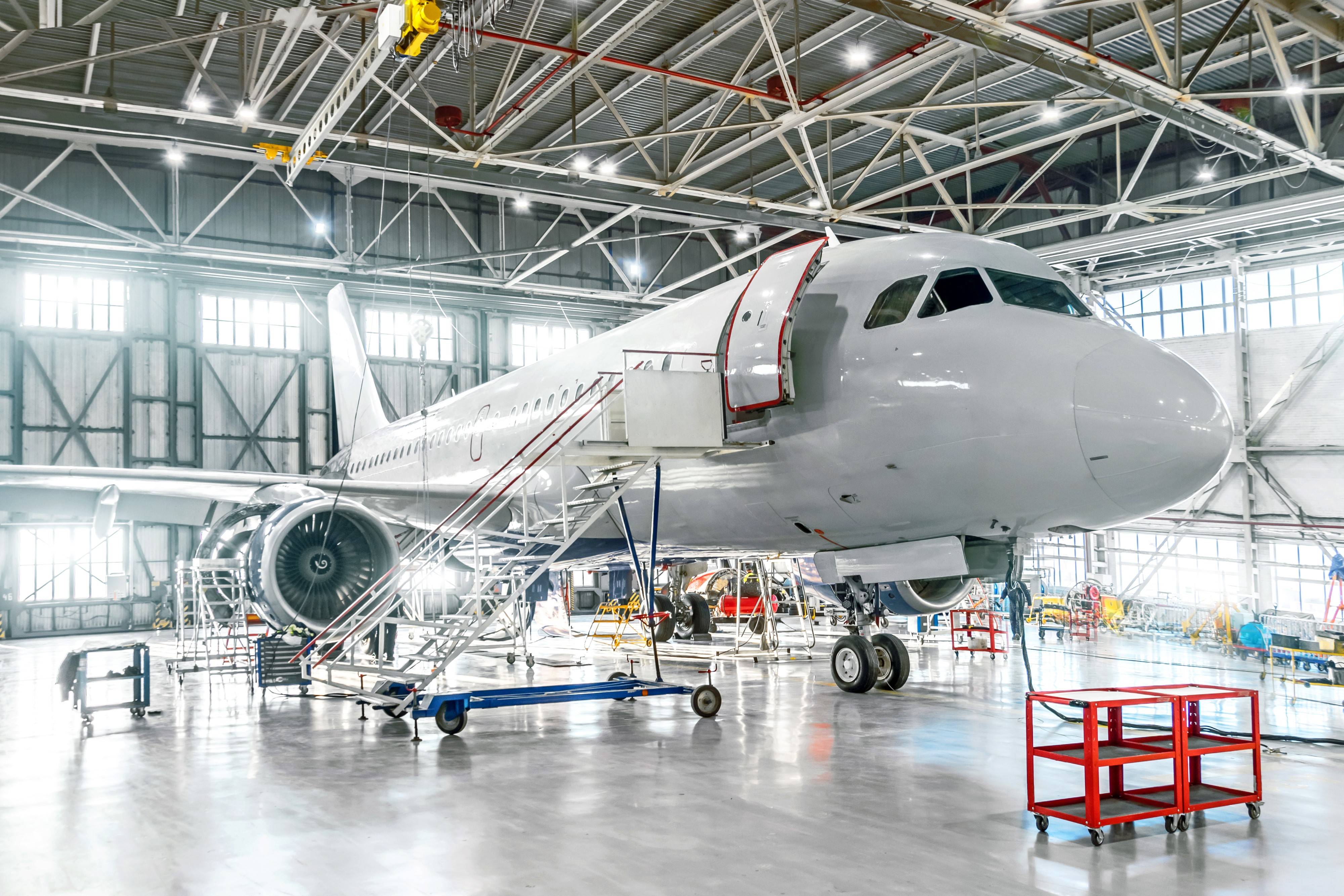 Aircraft under maintenance, checking mechanical systems for flight operations. Plane in the hangar.