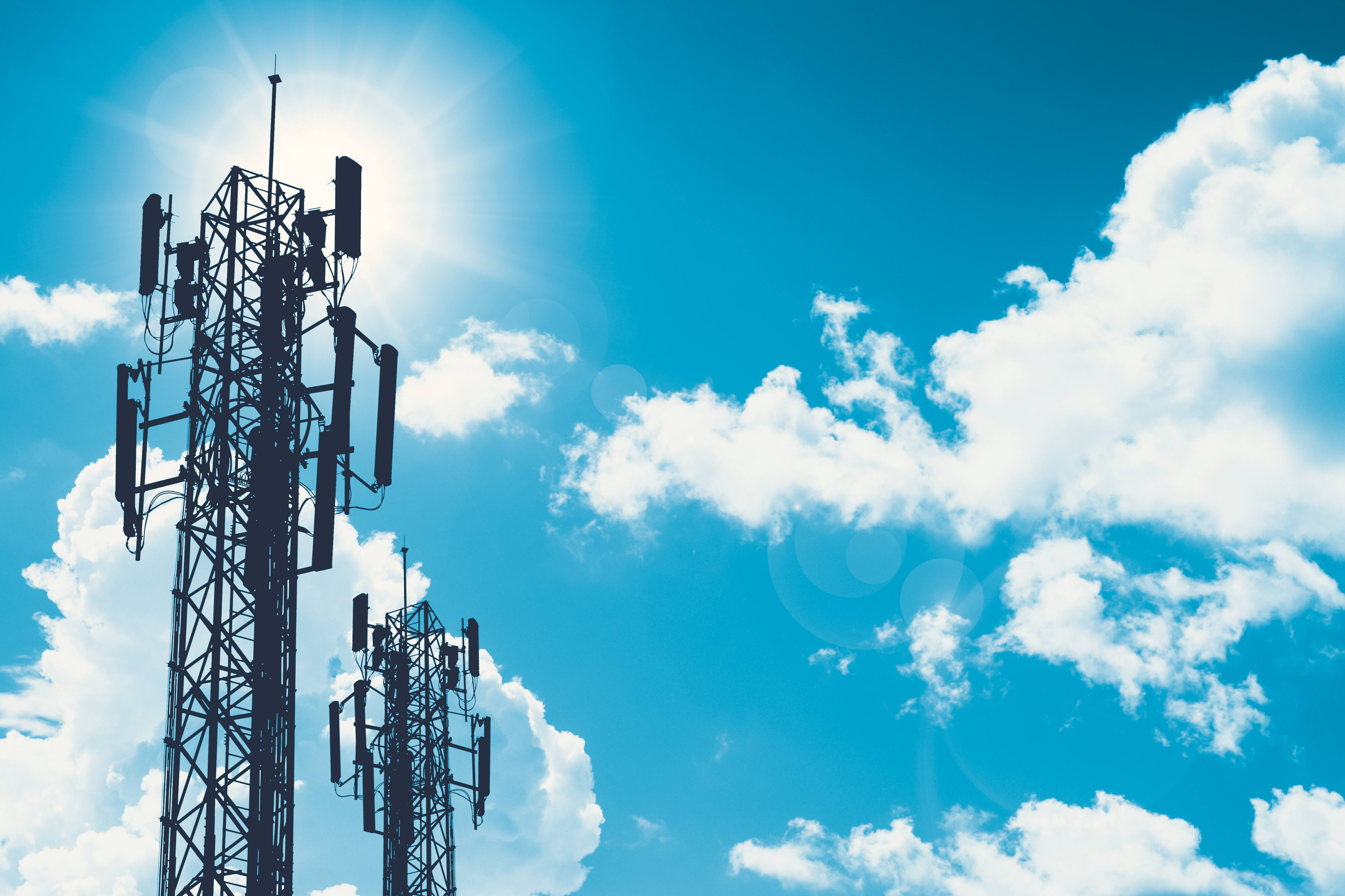 Communication tower or 3G 4G network telephone cellsite silhouette on blue sky and space for text